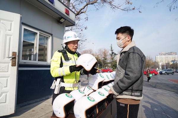 民警为市民介绍取用头盔操作流程。宿迁公安供图