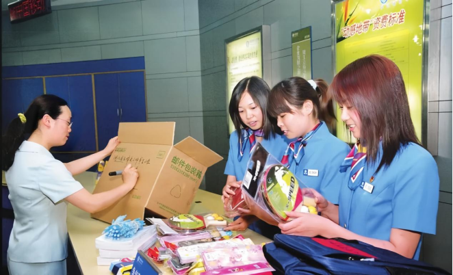 2003年，曹丽萍（左）给三坪希望小学寄送文具。江苏移动供图