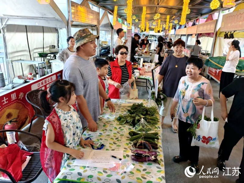 王维友带着小邻居在夜市摆起“一元蔬菜义卖”摊。人民网记者 马晓波摄