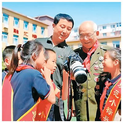 姚振锋（左四）与老兵来到学校开展爱国主义教育活动。厉飞摄