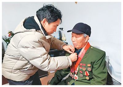 郭宏伟（左）在为抗战老兵整理衣装。王保军摄
