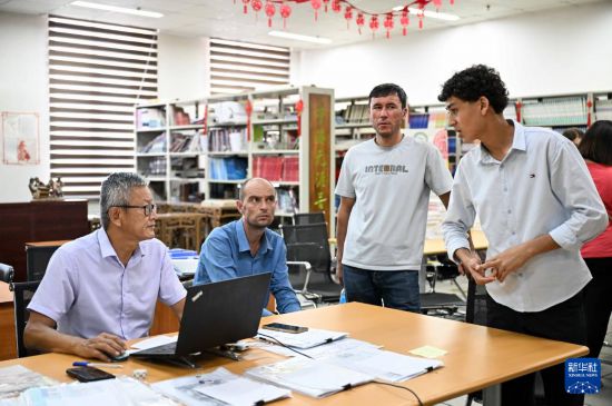 9月12日，在塔吉克斯坦首都杜尚别的国家图书馆中国厅，17岁的阿卜杜拉希姆（右一）与李建军老师（左一）用中文交流。新华社记者 李任滋 摄