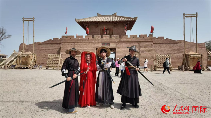 意大利艺术家马泰奥、罗马尼亚艺术家安德烈娅与中国艺术家吴穹等体验中国传统服饰。人民网 严小晶摄