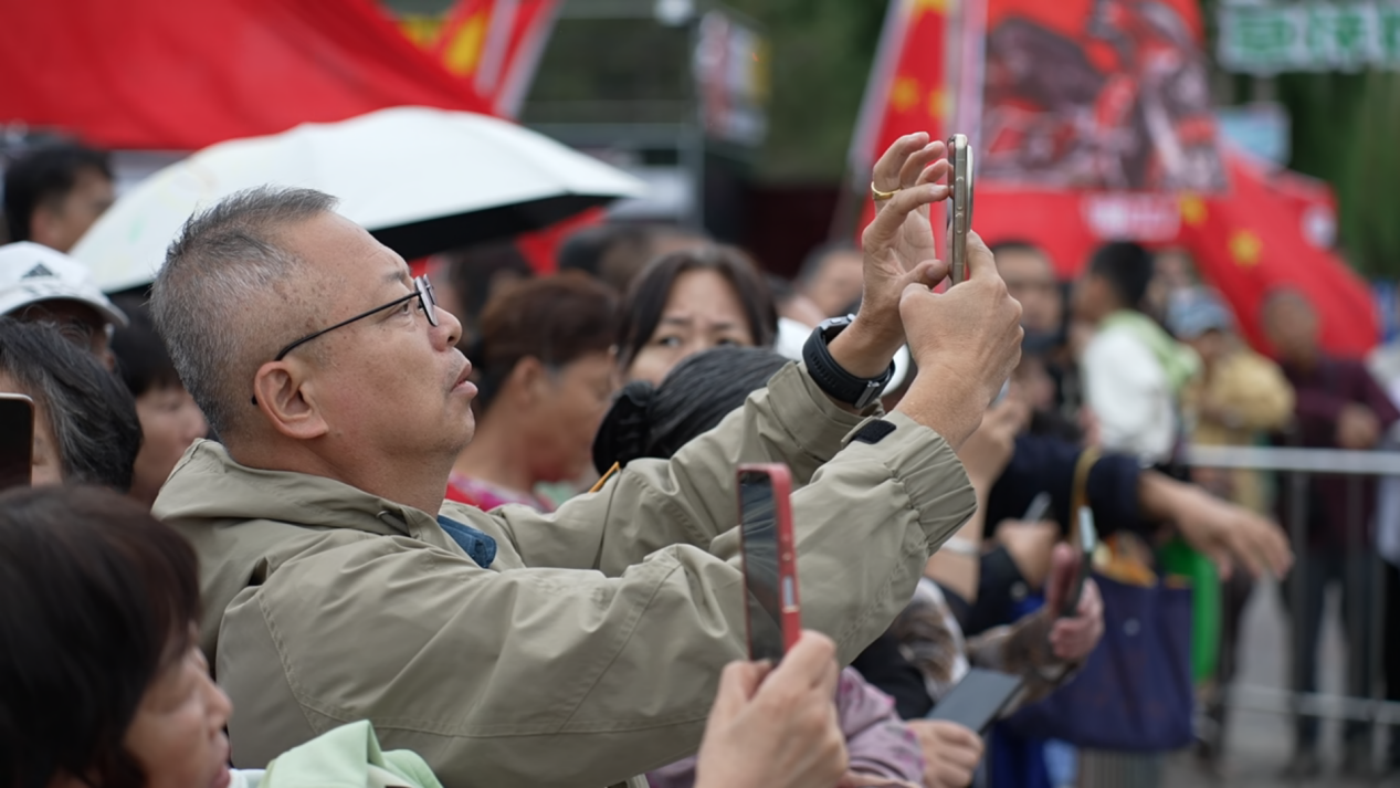 在百狮园南川古渡水路巡游表演区，游客们纷纷举起手机，记录这场融合古今的文旅盛宴。贾玉龙摄