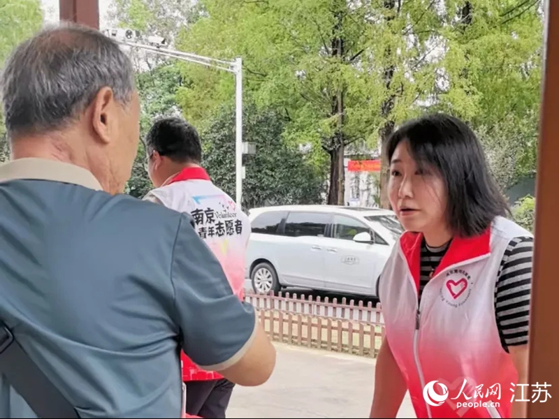 景区门口，志愿者在为游客讲解乘车路线。人民网 崔小倩摄