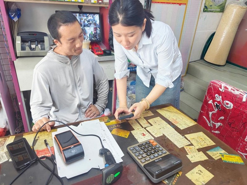 烟草工作人员陈月娟指导零售店主做线上社群运营。杨璐摄